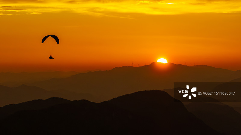 湖北崇阳——翱翔在日出晨光中的滑翔伞飞行员图片素材