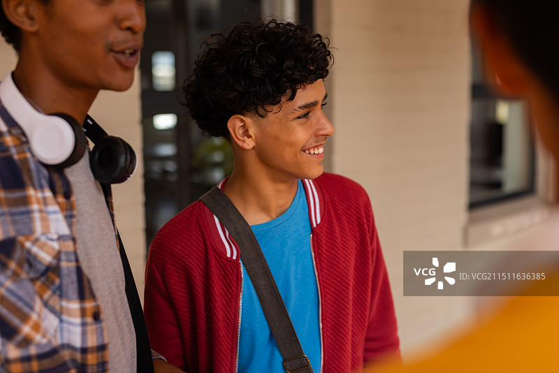 高中里穿着休闲装与朋友交谈的青少年男孩图片素材
