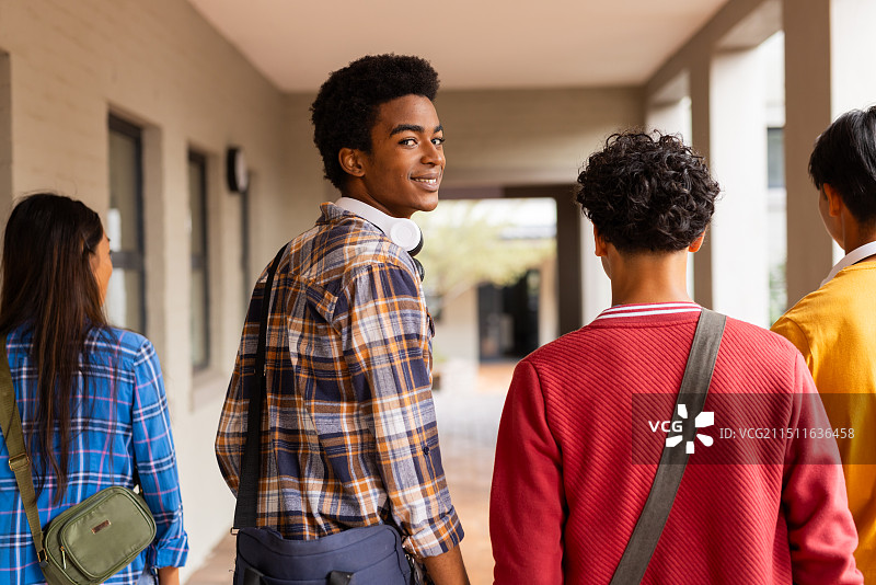 高中走廊里的学生，穿着休闲服装聊天和微笑图片素材