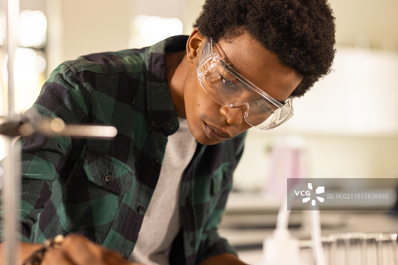 青少年戴着安全护目镜在高中教室里做科学实验图片素材