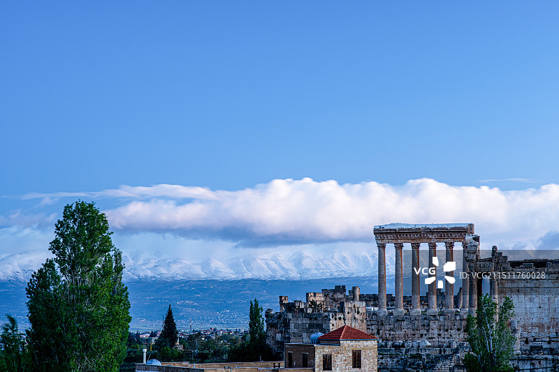 黎巴嫩著名景点考古遗迹世界文化遗产巴勒贝克（Baalbek）遗址中清晨的朱庇特神庙和雪山的壮丽风光图片素材