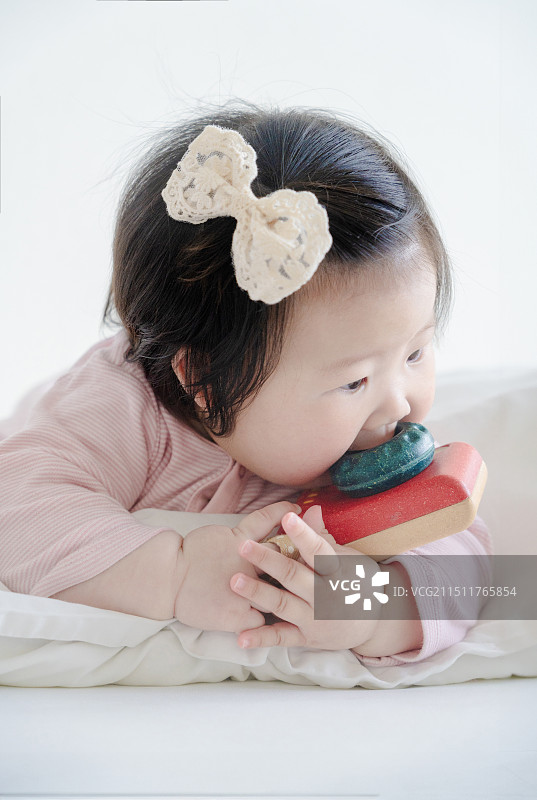 玩照相机的六个月粉色女婴特写图片素材