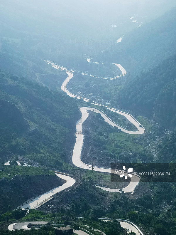 云雾笼罩下的茶山蜿蜒曲折的盘山路图片素材