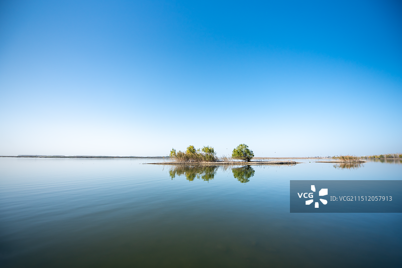 蓝调时刻江中的小岛和鸟群图片素材