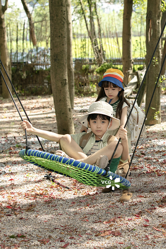 在户外玩秋千的三个小朋友图片素材