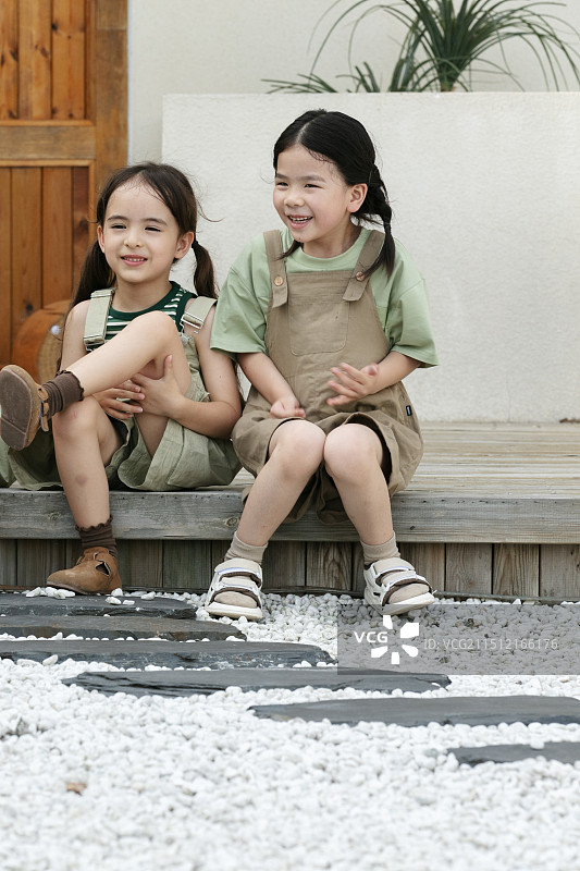 坐在度假屋前面的三个小朋友图片素材