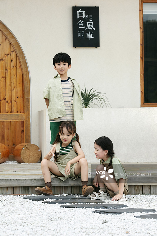坐在度假屋前面的三个小朋友图片素材