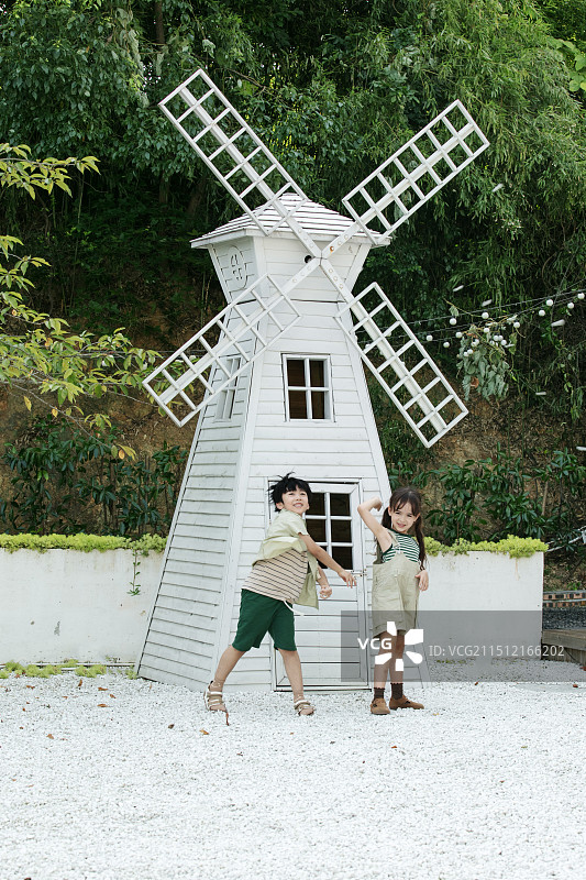 在风车屋前丢石子的小朋友图片素材