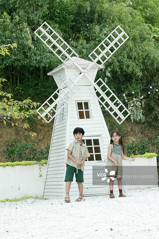 在风车屋前丢石子的小朋友图片素材