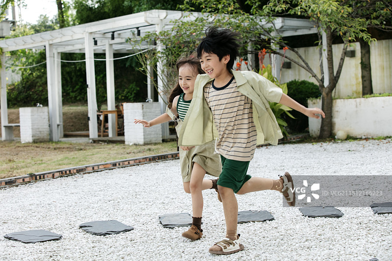 肩并肩奔跑的两个小朋友图片素材