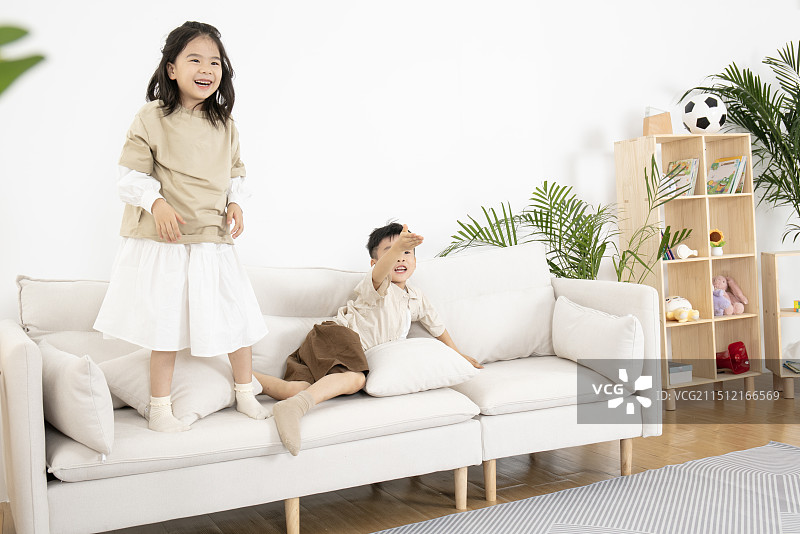 在客厅玩飞机模型的两个小朋友图片素材