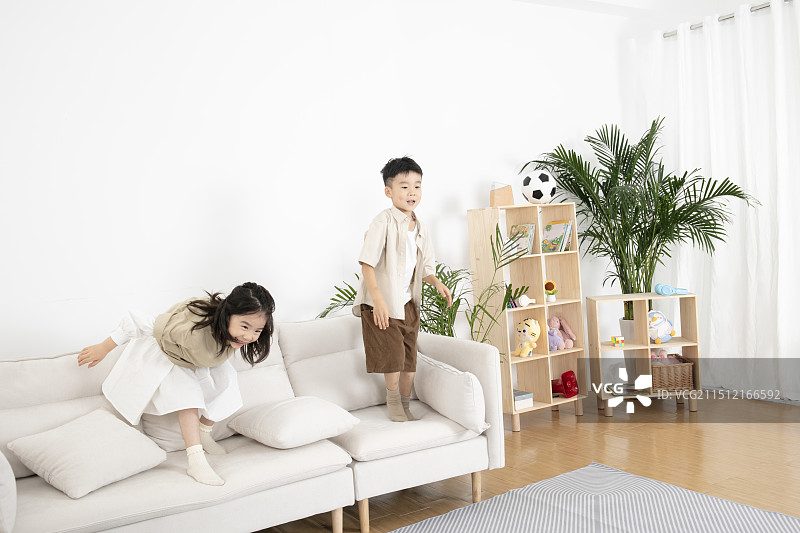 在客厅玩飞机模型的两个小朋友图片素材