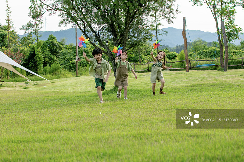 玩风车的三个小朋友图片素材
