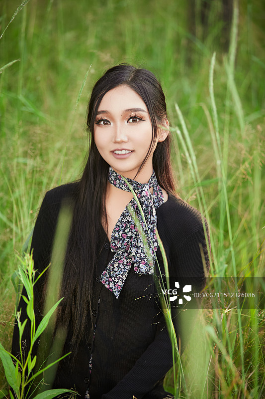 盛夏夕阳照射下花丛草地中的亚洲美女图片素材