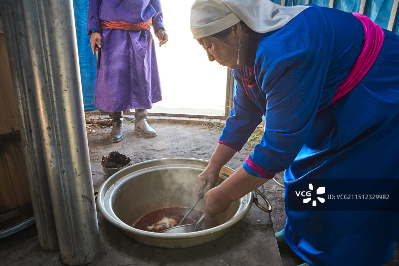 在蒙古包内用传统工艺熬煮蒙族奶茶的过程图片素材