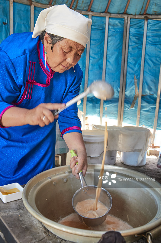 在蒙古包内用传统工艺熬煮蒙族奶茶的过程图片素材