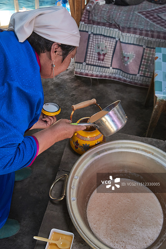 在蒙古包内用传统工艺熬煮蒙族奶茶的过程图片素材