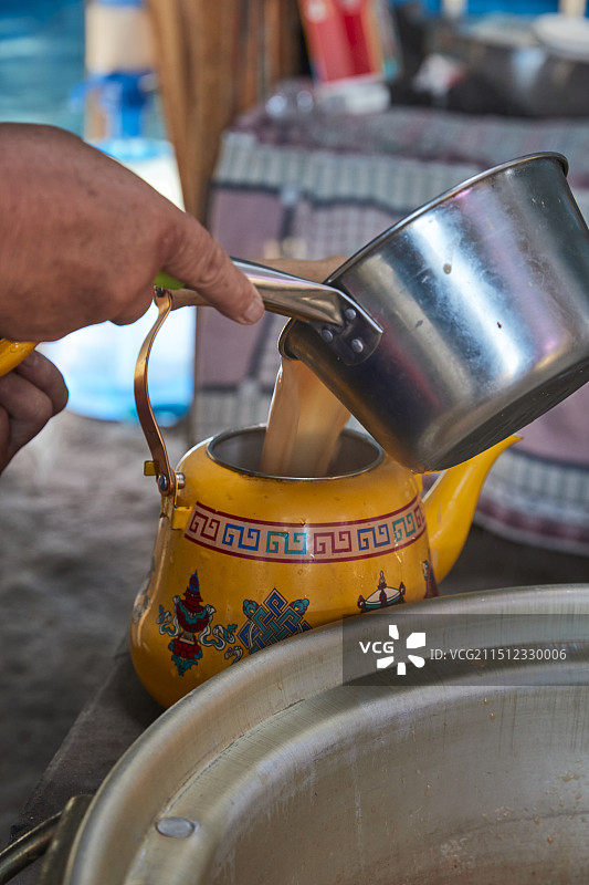 在蒙古包内用传统工艺熬煮蒙族奶茶的过程图片素材