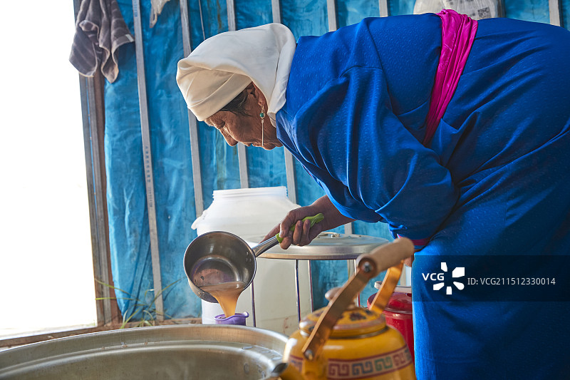 在蒙古包内用传统工艺熬煮蒙族奶茶的过程图片素材