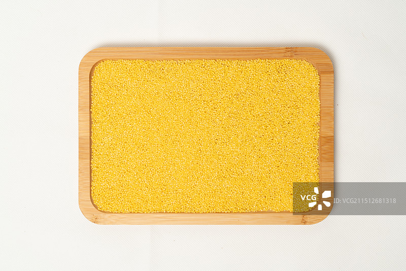 白色背景的木盘中的小米，粗粮图片素材