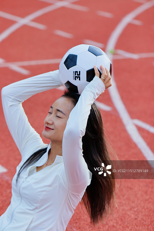 在草地上玩足球的年轻女子图片素材