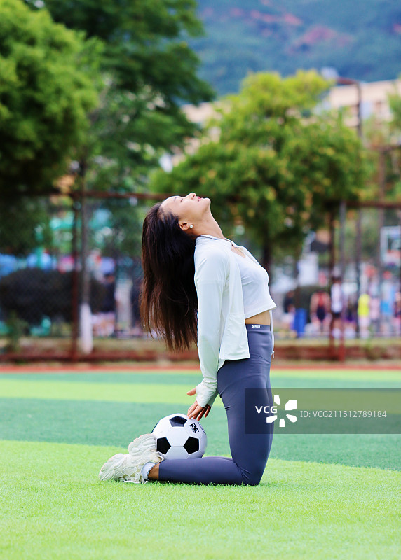 在草地上踢足球的女孩图片素材
