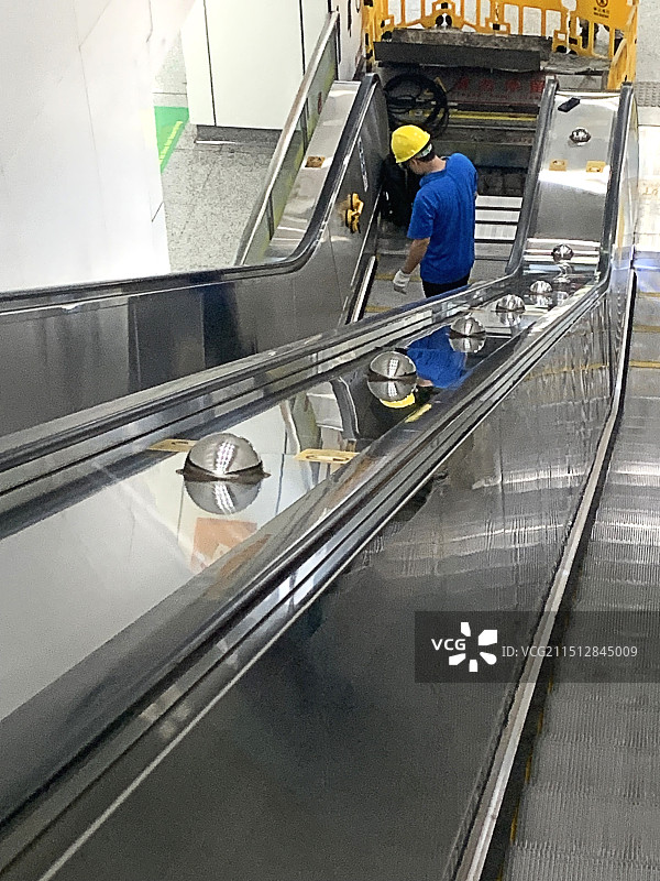 2个工人在自动扶梯维修图片素材