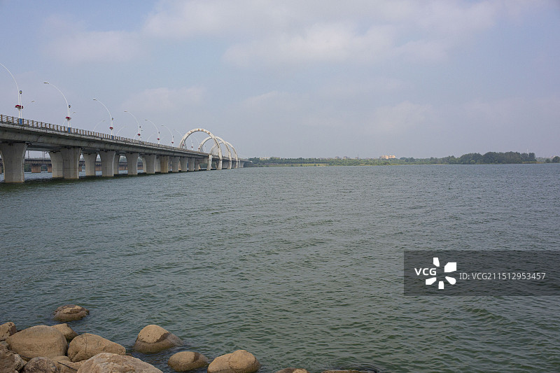 城市天空下湖边的高层建筑及大桥特写图片素材