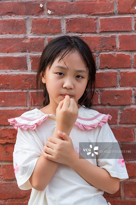 砖墙前的乡村留守儿童生活肖像图片素材