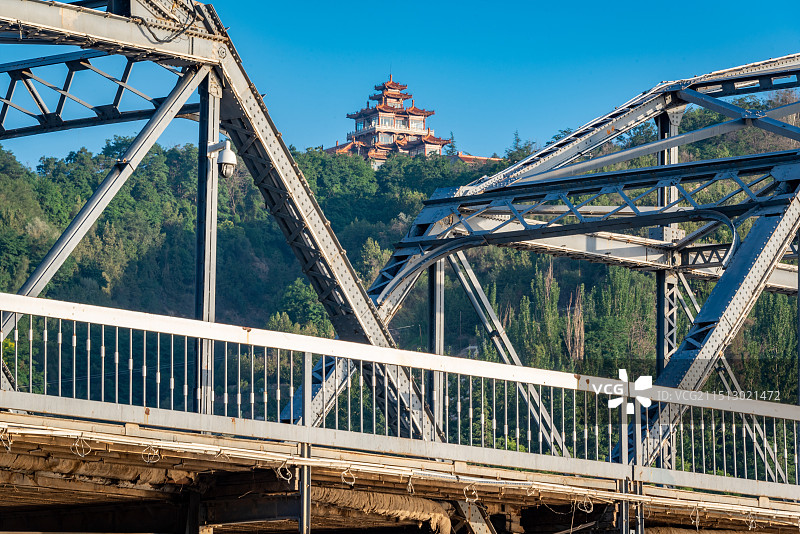 日出时分的兰州市区朝阳刚刚从地平线升起，射出温暖的阳光，黄河铁桥联通黄河两岸，背后是白塔山上的建筑图片素材