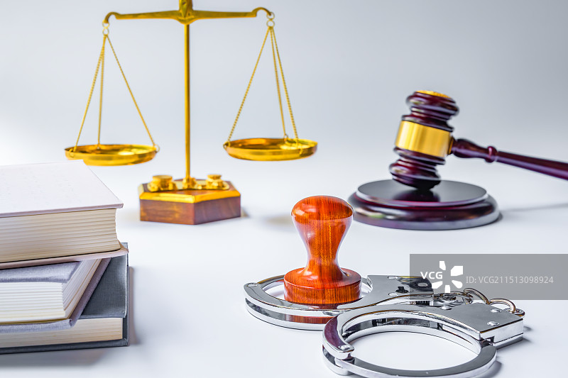 手铐、木制印章、书籍、天平、法槌与白色背景图片素材