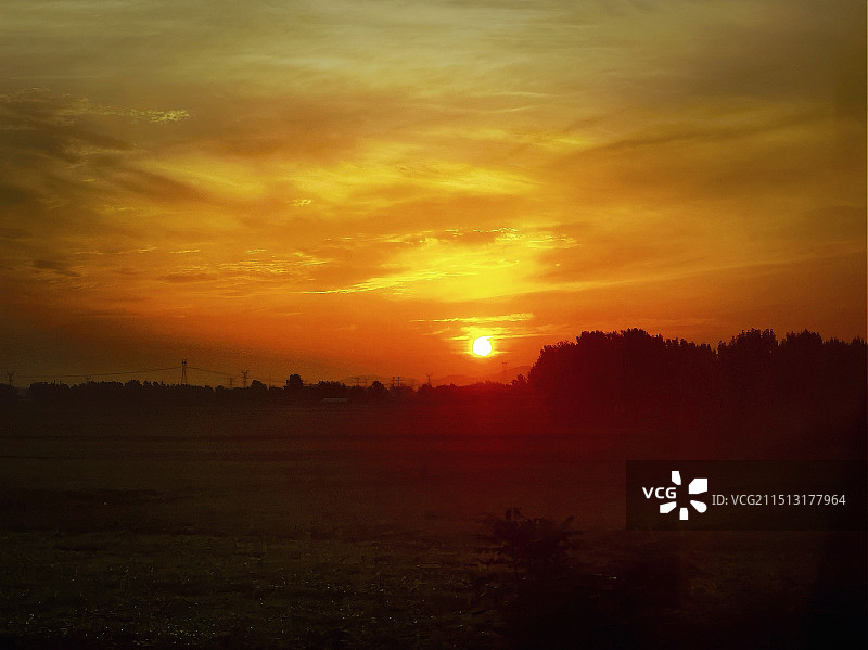 黄土高原上橘色天空衬托下的“红霞与田野”剪影景观图片素材