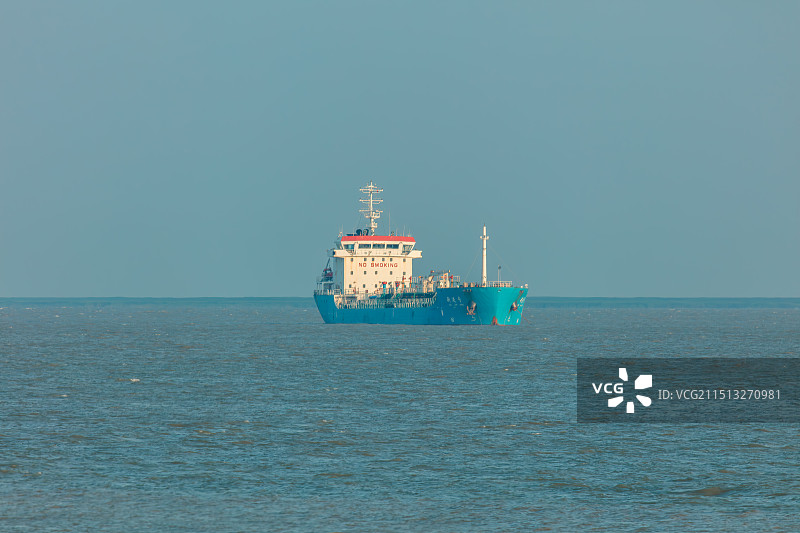 上海崇明横沙岛通海大堤附近海域，长江入海口，一艘航行中的蓝色货轮图片素材