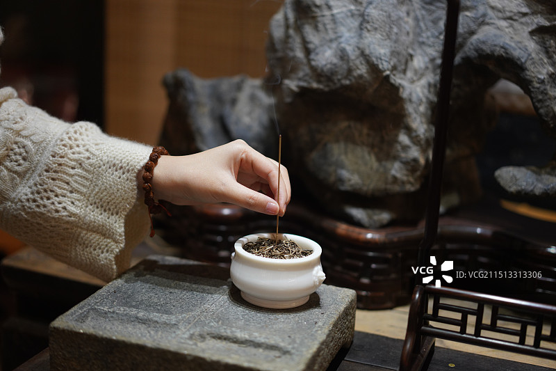 青年女人在茶室点沉香线香的手部动作特写图片素材