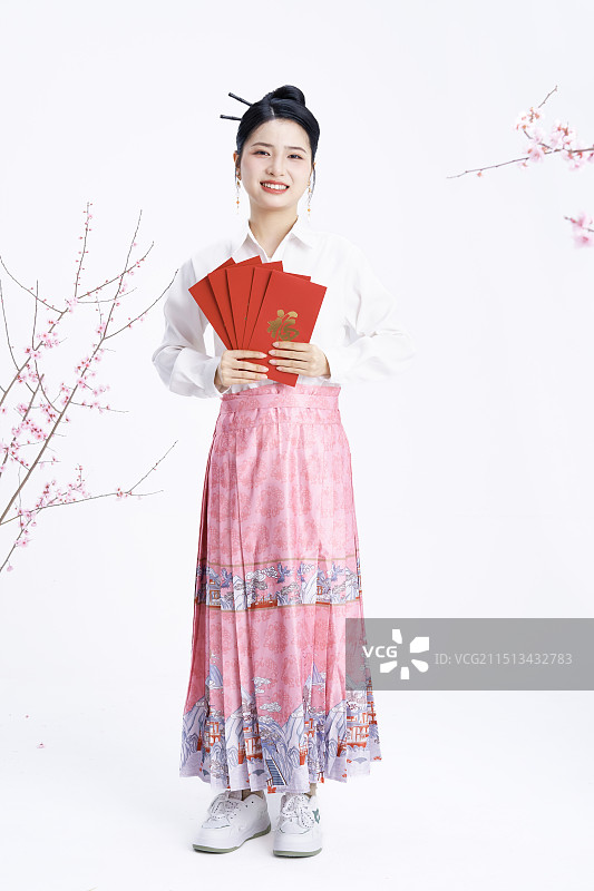 手拿红包身穿马面裙的年轻中国女人图片素材