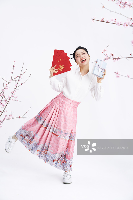 手拿红包与礼盒的年轻中国女人图片素材