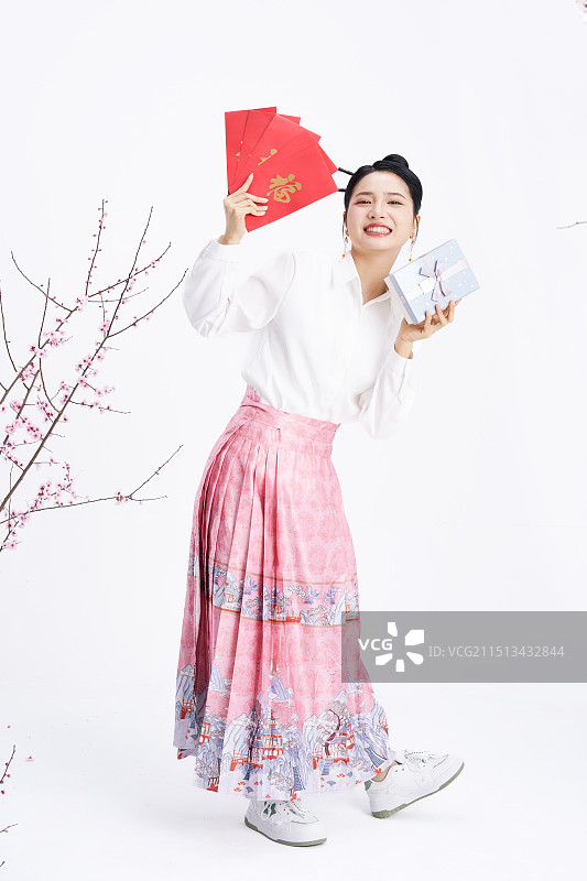 手拿红包与礼盒的年轻中国女人图片素材