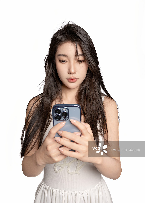 白色背景前使用手机的东方女性年轻美女图片素材