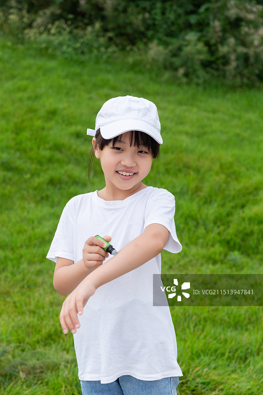 在户外涂抹驱蚊液的亚洲小女孩图片素材