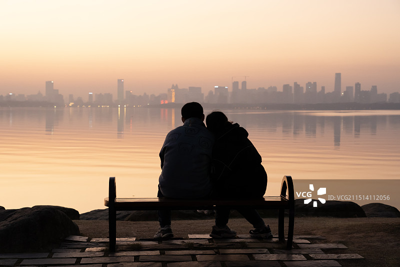 一对情侣在夕阳的湖边紧紧相拥图片素材