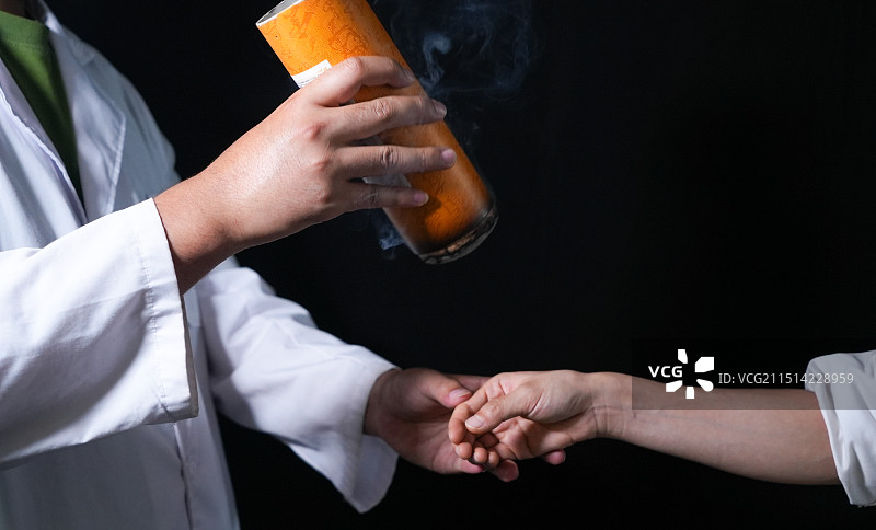 中医理疗  艾灸  做艾灸手部特写（纯黑背景拍摄艾灸条）图片素材