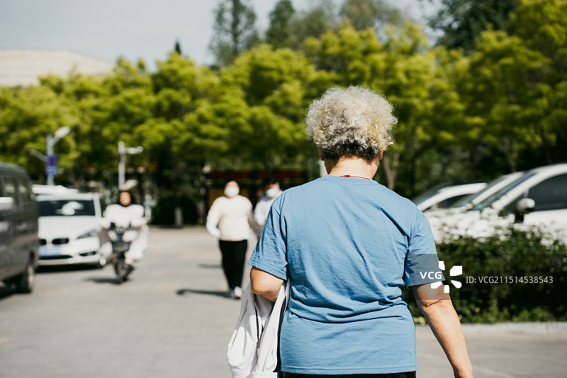 站在城市街道上的老年妇女的后视图图片素材
