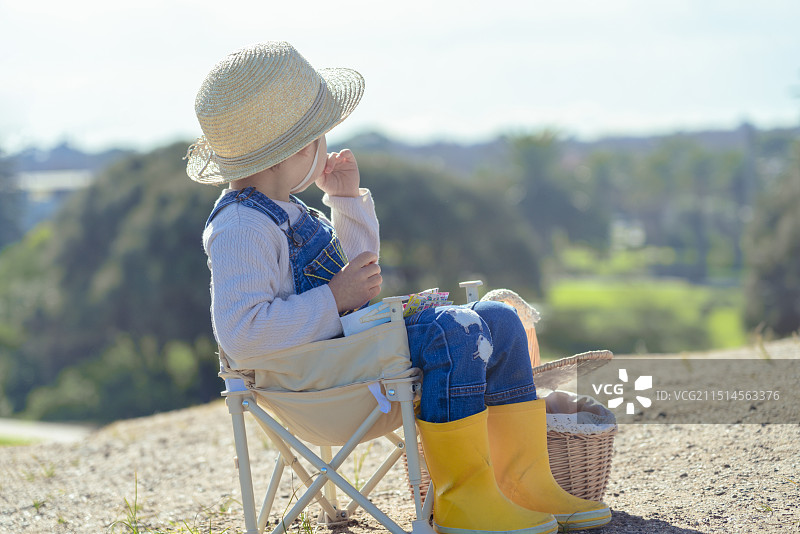 城市海滩公园高坡上休闲享受的草帽男孩图片素材