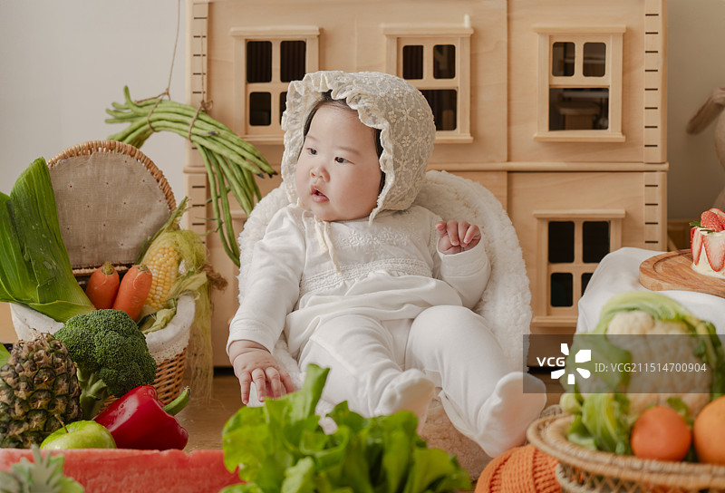 穿白色礼服套装的女婴与新鲜丰盛果蔬 静物图片素材