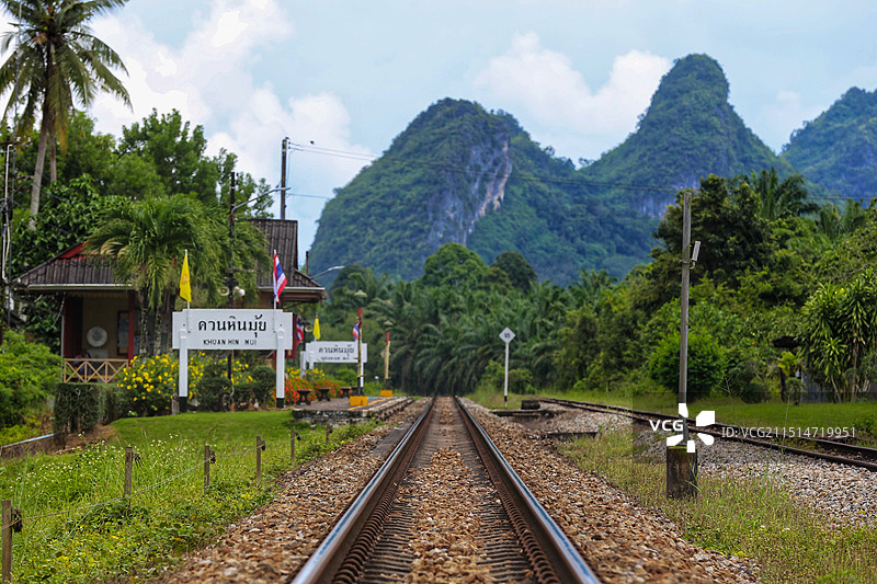 铁路轨道延伸至远方的山峦，显得骨外壮丽，画面中有一座小火车站图片素材