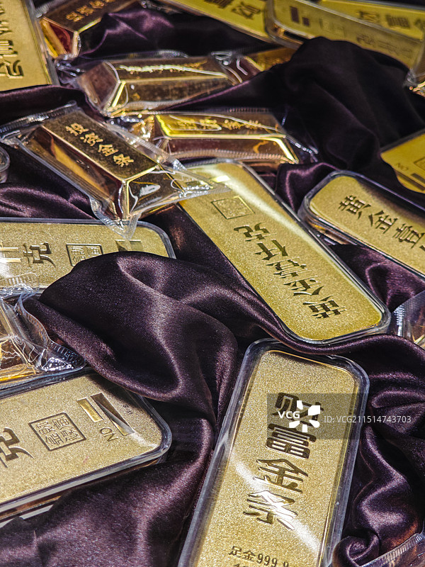 锦缎中堆放的一堆金条实物图片素材