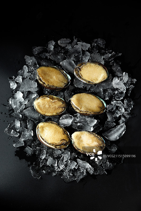 黑色背景下碎冰块鲍鱼的俯视镜头图片素材