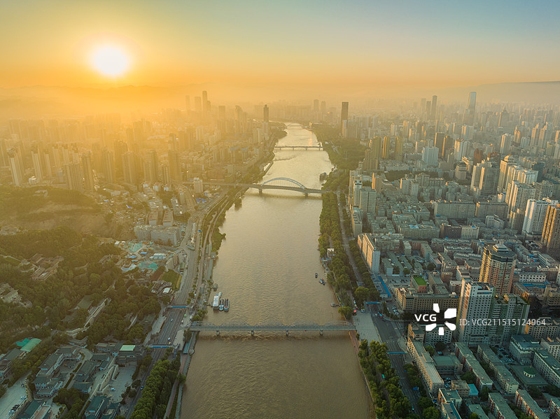 航拍日出时分的兰州市区朝阳刚刚从地平线升起，射出温暖的阳光，黄河铁桥等几座桥联通黄河两岸高楼鳞次栉比图片素材