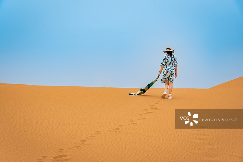 蓝天白云下的大漠黄沙，宁夏中卫沙漠头腾格里沙漠金黄色的沙漠中一汪泉水和白色的木屋度假氛围图片素材