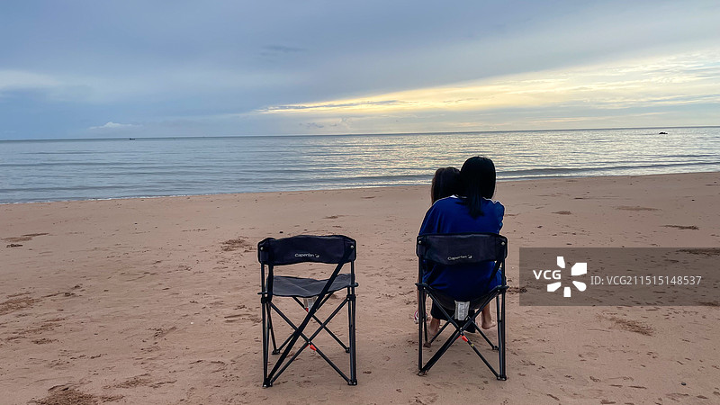 沙滩上坐在椅子上的母女正在享受海景图片素材